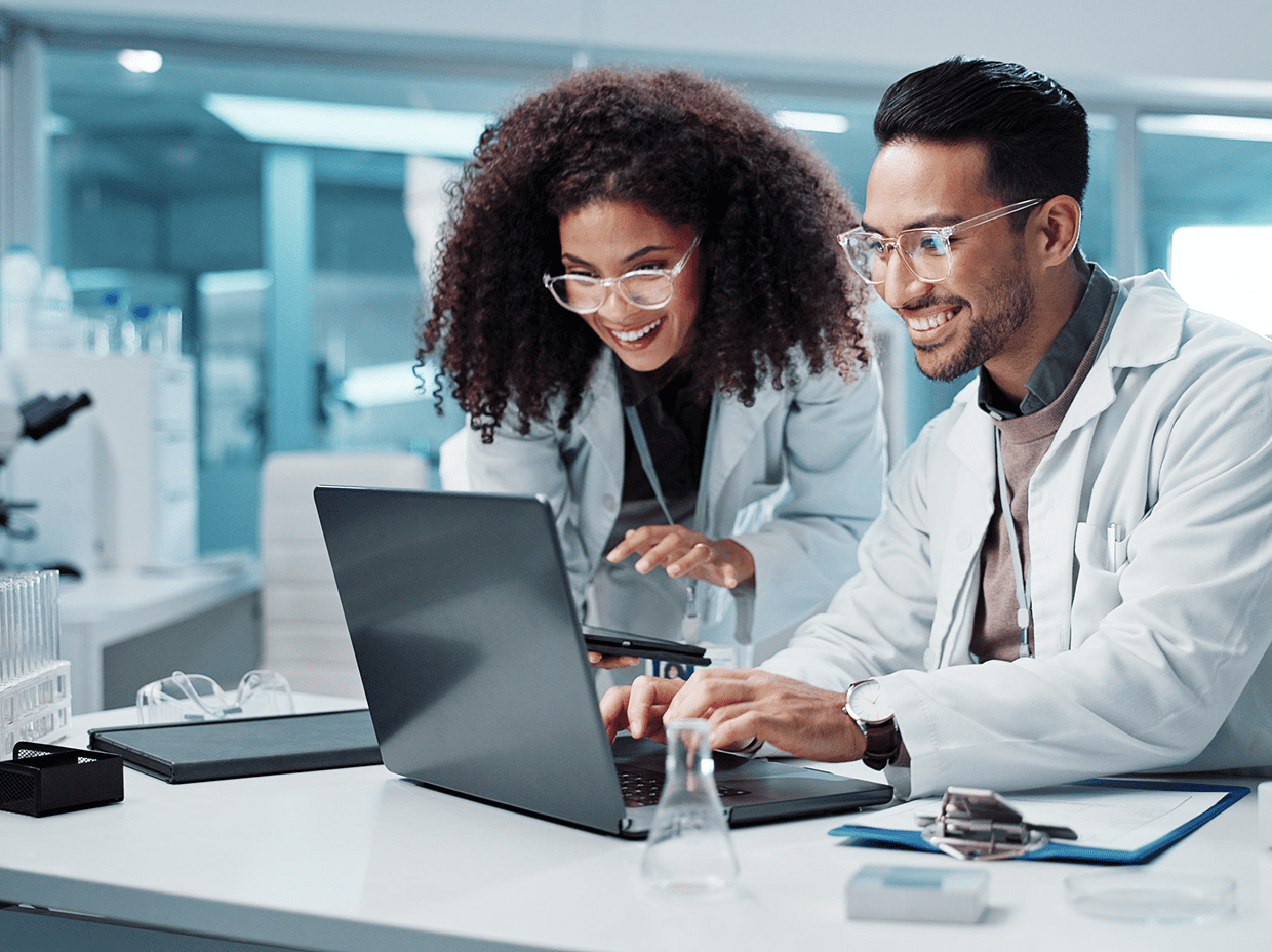 Scientists collaborating on a laptop in laboratory.