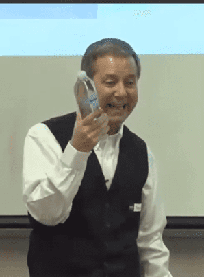 Man enthusiastically speaking with a phone in hand.