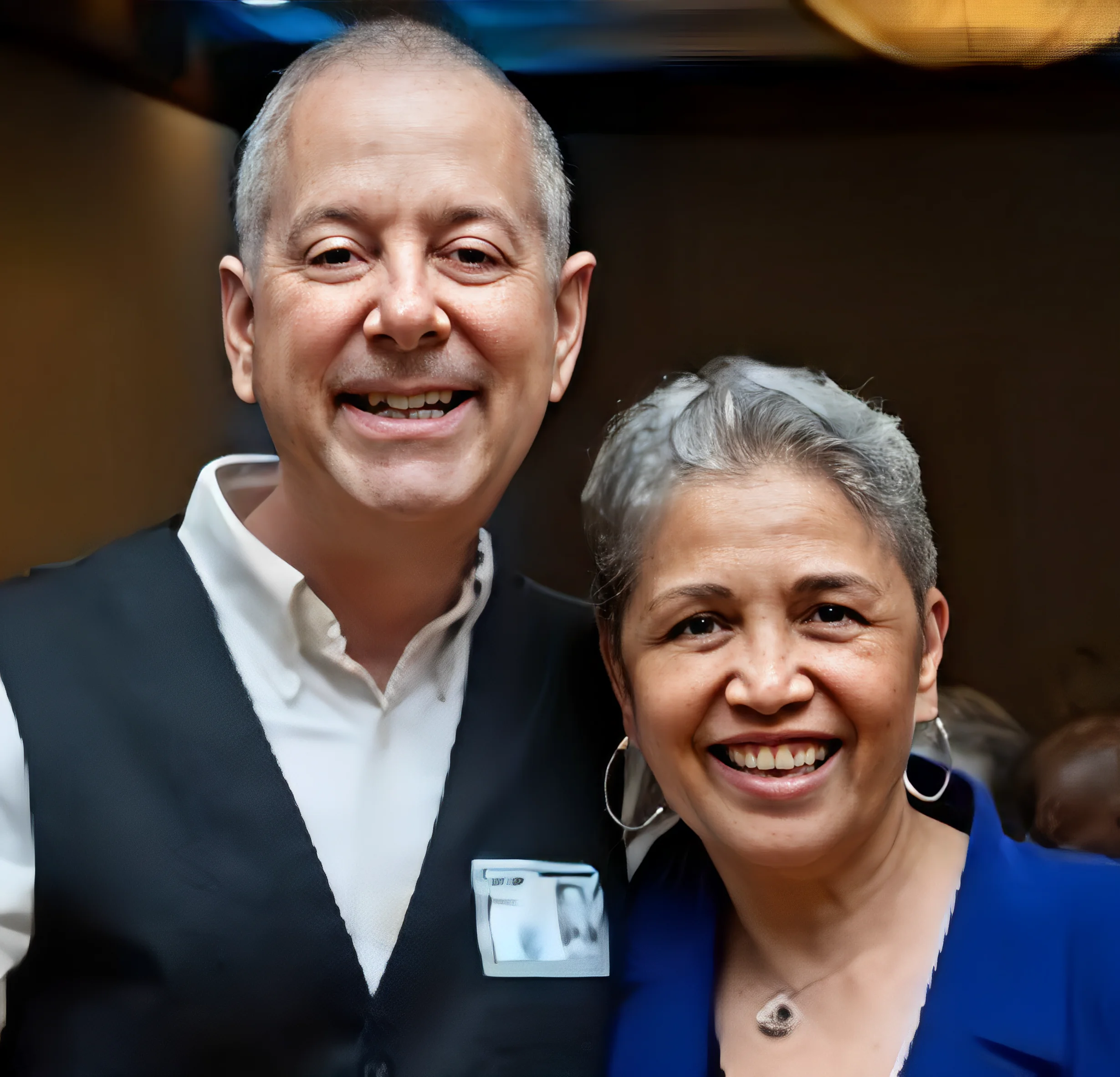 Two smiling people posing for a photo indoors.