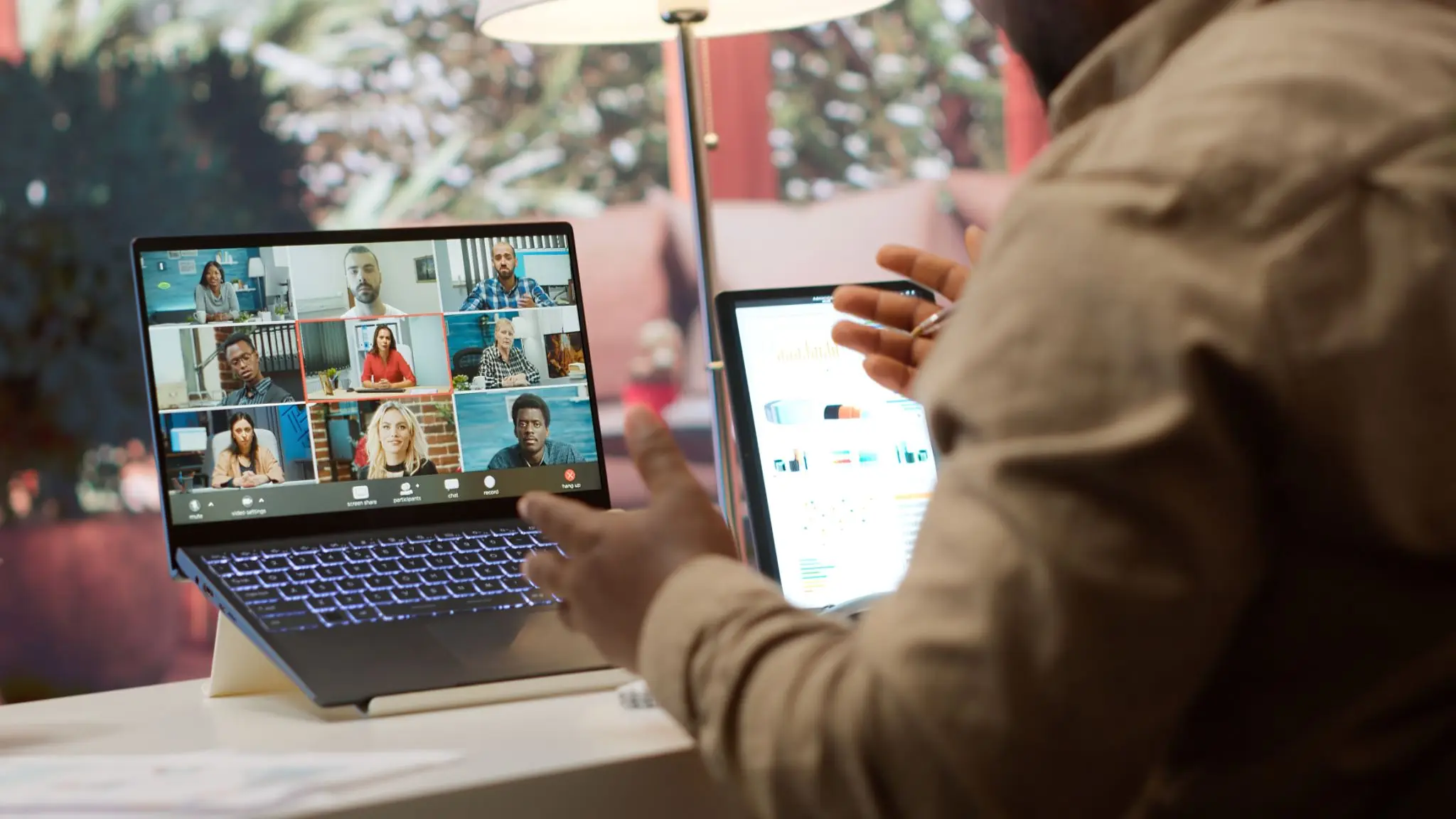 Person engaged in a virtual meeting on a laptop with multiple participants.