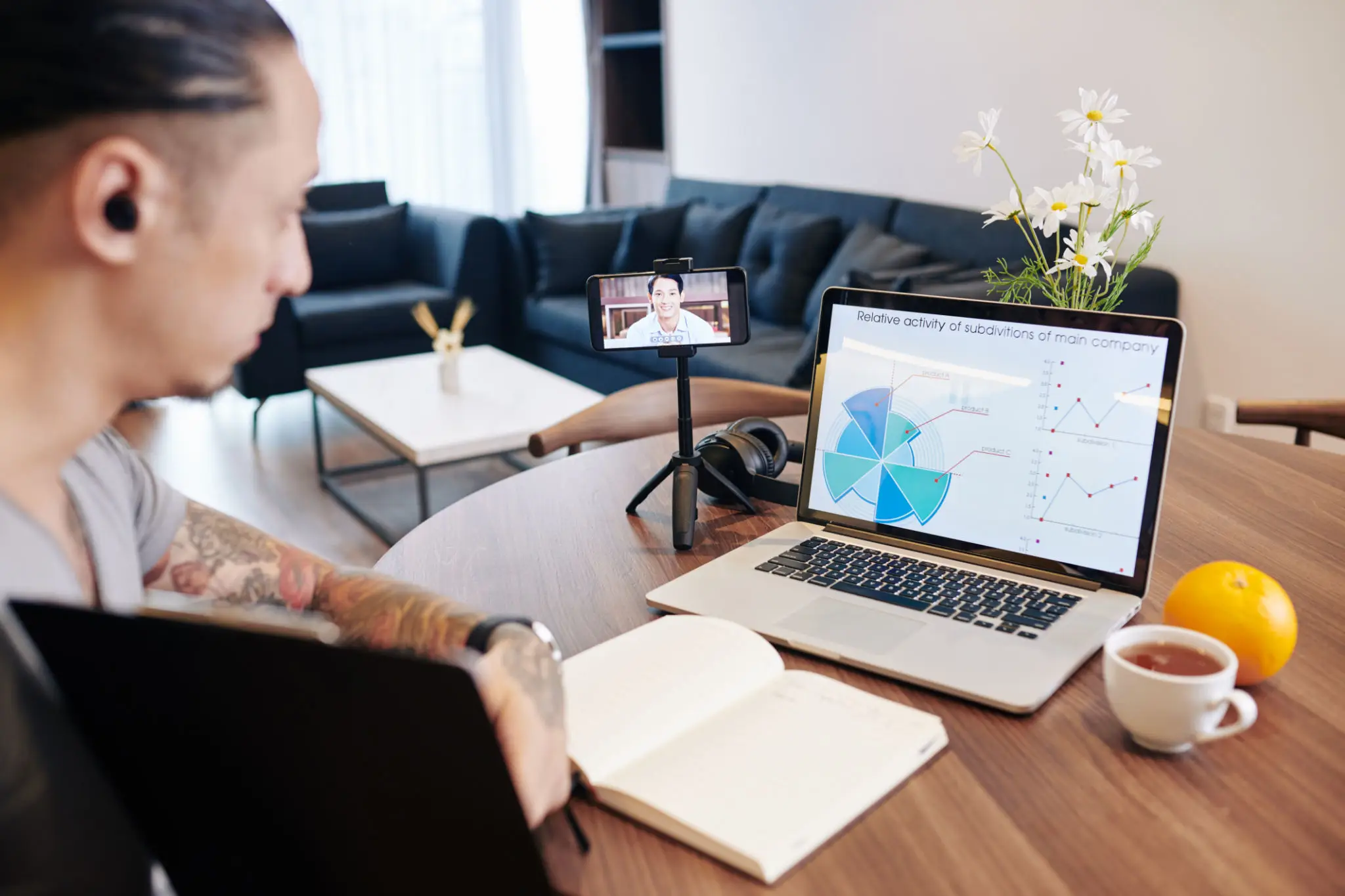 Woman attending a virtual meeting with charts on her laptop.