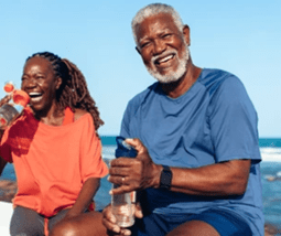 Portrait of a man smiling gently against a teal background.