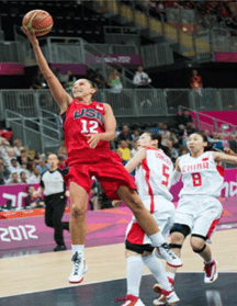 Portrait of a man smiling gently against a teal background.