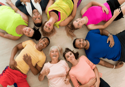 Diverse group of women lying in a circle, smiling and enjoying each other's company.